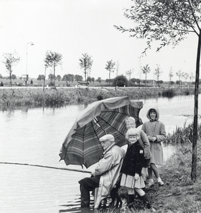603905 Afbeelding van een vissende man met enkele kinderen, tijdens regenachtige omstandigheden, langs de Leidsche Rijn ...